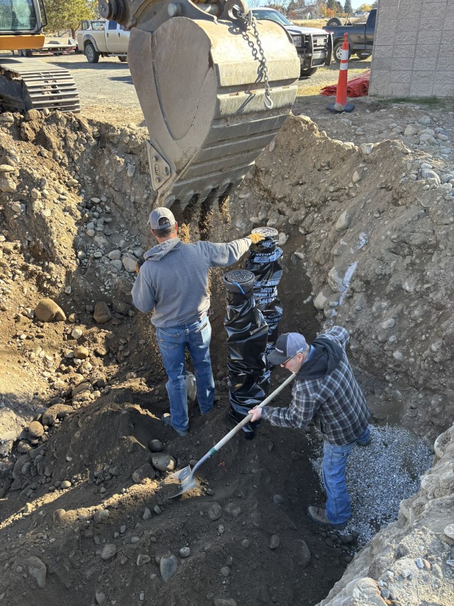 Men Backfilling Well Valve Boxes